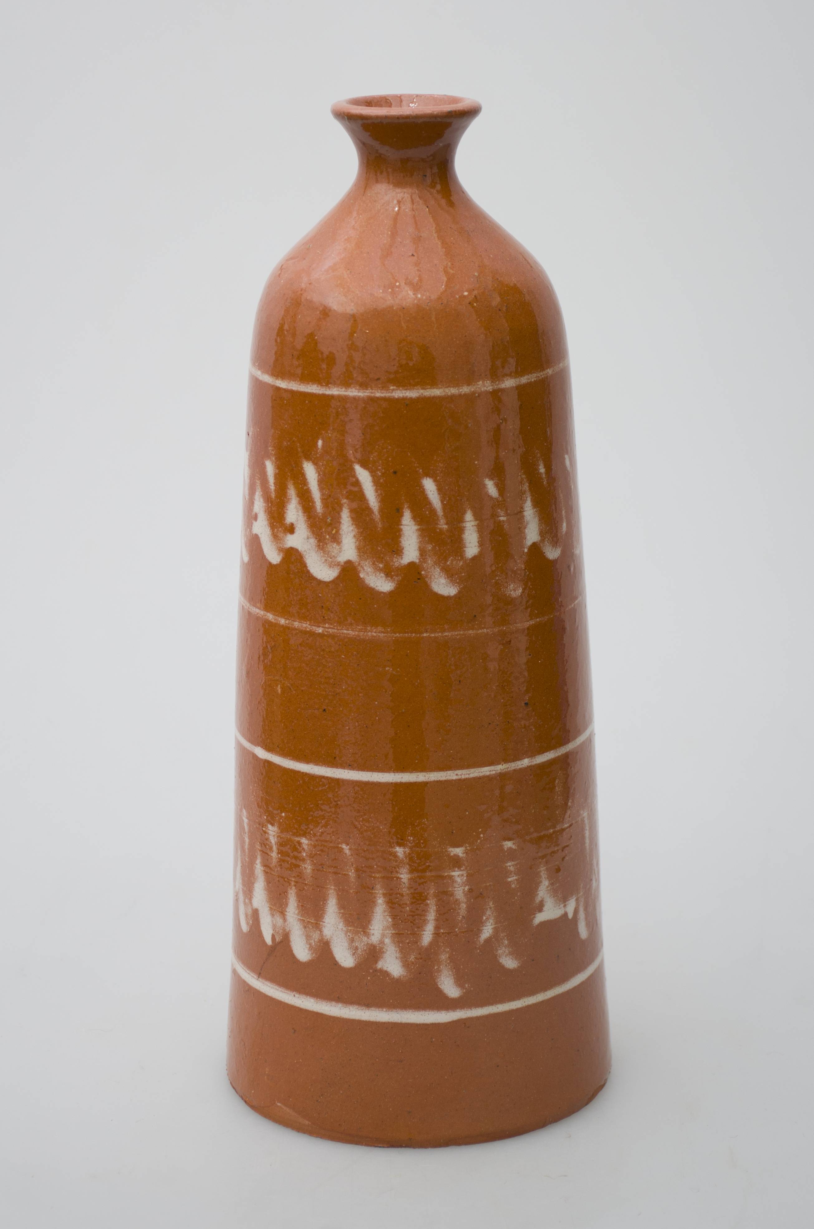 Piesă ceramică smălțuită, de formă tronconică, cu baza plată și lărgită, ce se subțiază spre gâtul scurt. Fundul vasului prezintă un orificiu patrulater, de mari dimensiuni. Interiorul vasului este gol, având formă aproximativ cilindrică. Pereții exteriori au fost decorați cu motive geometrizante stilizate: două registre formate din câte o bandă circulară, peste care au fost realizate linii oblice în zig-zag. Câte două linii concentrice drepte încadrează decorul pictat. Forma era folosită pentru pregătirea cozonacului secuiesc. Prezintă uzură funcțională. Cromatică: fond: cărămiziu; motive: crem.