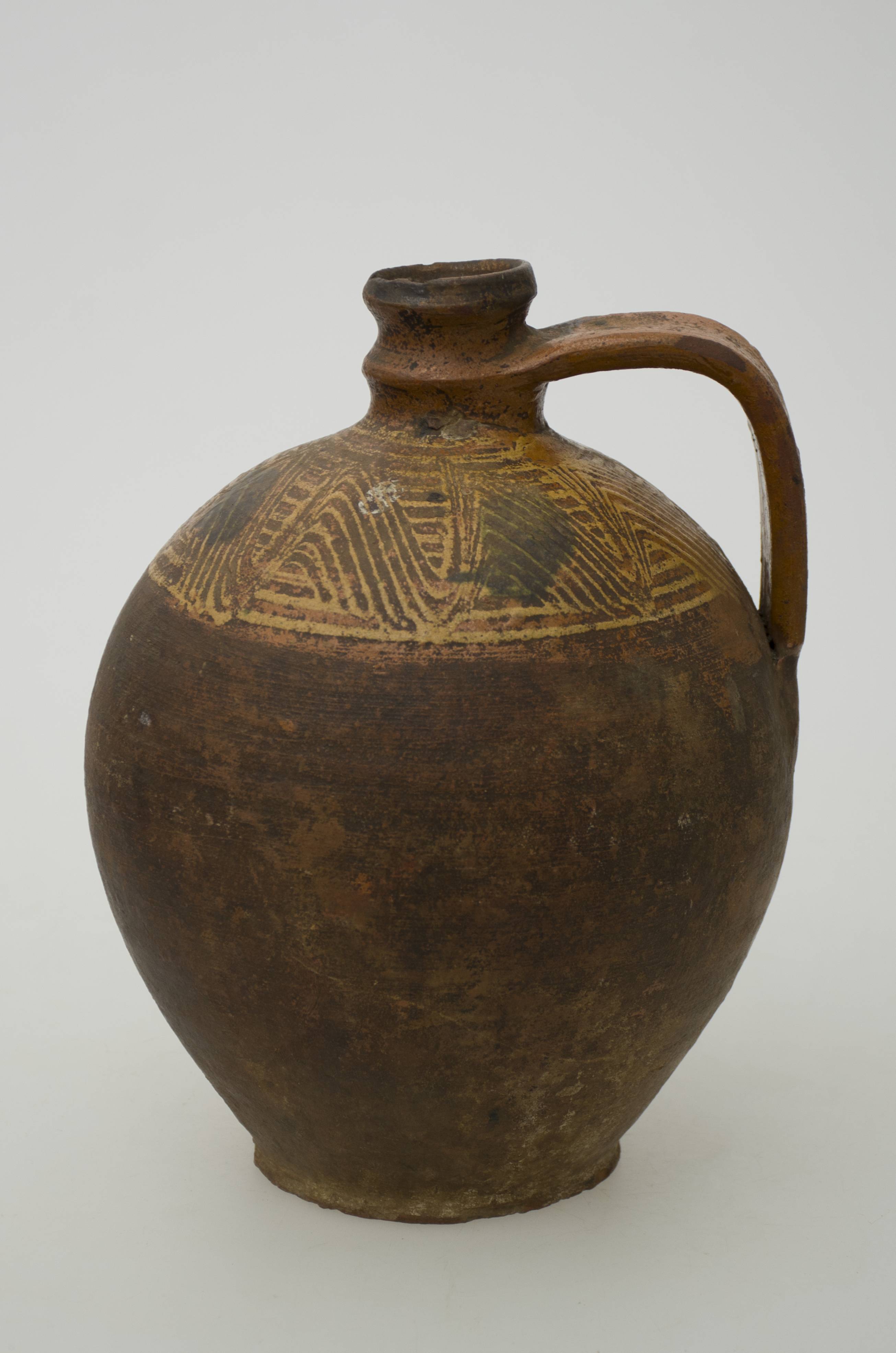 Vas ceramic de uz casnic, întrebuințat în gospodărie la stocarea și transportul lichidelor sau ca și element decorativ. Recipient de formă bitronconică, cu corpul globular/sferoidal, cu gâtul îngust și lunguieț. Partea superioară a gâtului reprezintă gura vasului. Este prevăzut cu o toartă laterală care pornește din zona mediană gâtului și se termină la jumătatea vasului. În jumătatea superioară a vasului și până sub gât se identifică un decor pictat care redă motive geometrice după cum urmează: cercuri concentrice paralele realizate din linii dreapte; linii meandrate paralele. Vasul a fost ars în tehnica arderii oxidante și prezintă urme de uzură. Cromatică: fond: cărămiziu; brun-roșcat; motive: gălbui.