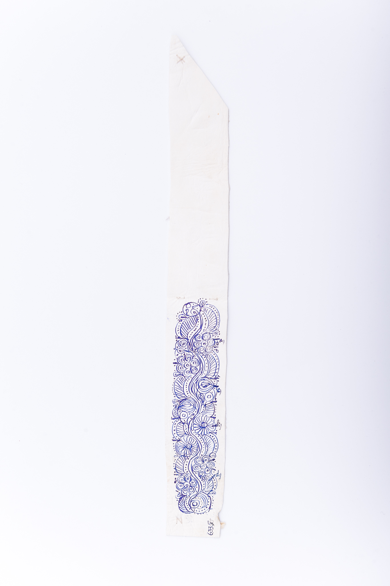 Tipar de broderie format dintr-o fâșie din piele, desenată pe jumătate, după un model vechi, din al doilea sfert sec XIX. Ornament de pe pieptarul femeiesc, scurt și crăpat, național. Interpretare naturalistă. Piesa este, pe jumătate, pe lungime, decorată cu desen de mână (fază de lucru) realizat cu penița și tuș negru. Registrul în faza de lucru se remarcă motivele numerotate cu ”a”, ”b”,”c” și ”d”. Decorul este redat de motive florale: ”a- trandafirul mic (6 petale)”, ”b- pintenul” și motive fitomorfe ”c- frunza viei (mare)” și motive skeomorfe ”d- brățări”. La colțul din stânga jos, în față, este scris numărul de inventar 6335. Colțurile și mijlocul broderiei sunt marcate cu fir alb, cu linii și ”X uri”. Cromatică: (fond) alb, negru.