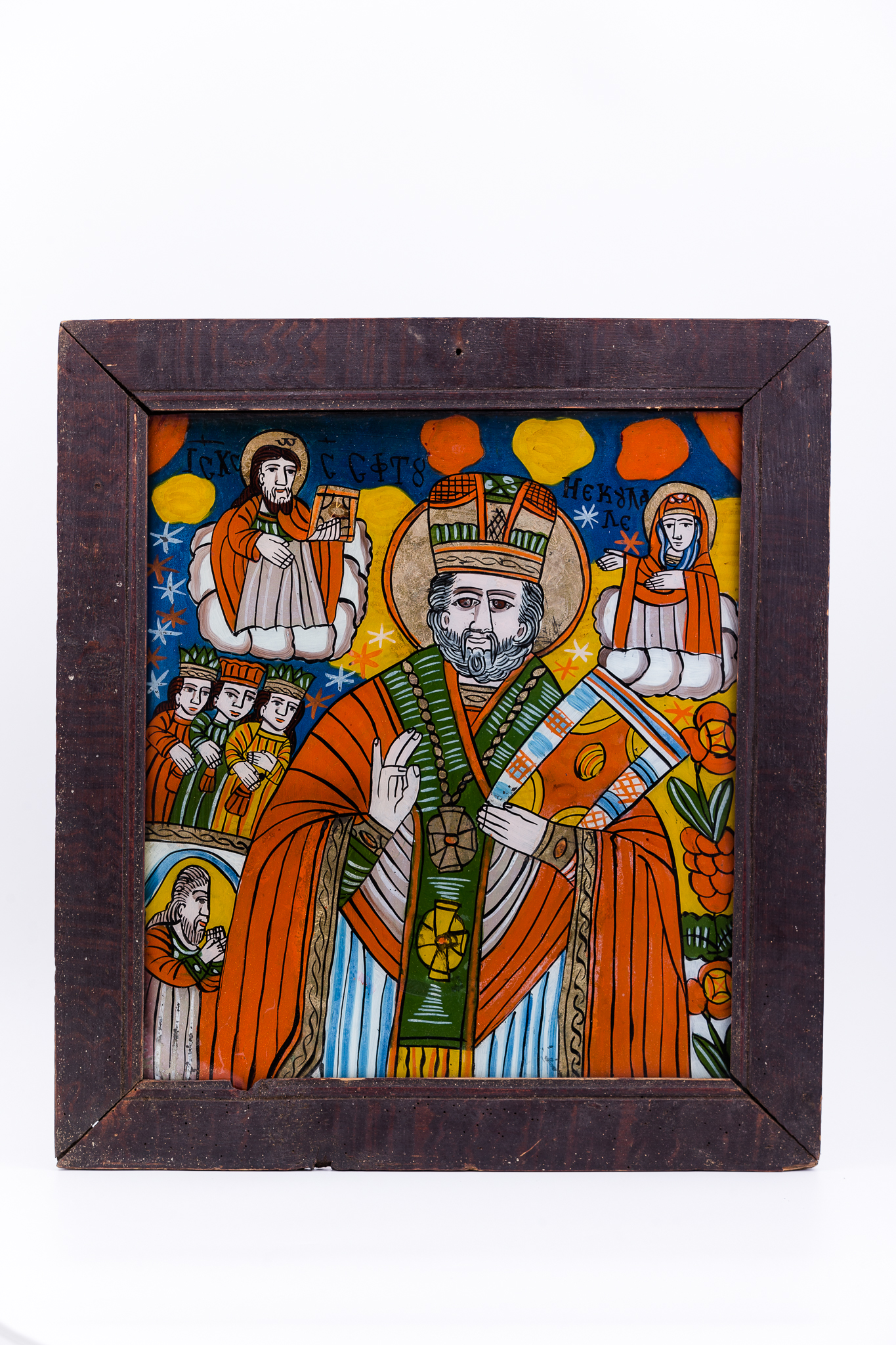 Sfântul Mare Ierarh Nicolae, făcător de minuni, este îmbrăcat în veșminte liturgice, de ierarh, sacos roșu-vermillon, galben-ocru și verde spanac-avocado, cu epitrahil-patrafir verde, cu engolpion brun-bronziu. Sfântul Nicolae ține în mâna stângă Sfânta Evanghelie închisă și cu dreapta Binecuvântează. Este unul dintre cei mai populari și iubiți sfinți, ocrotitor al caselor, familiilor și copiilor. Are barbă sură, mithră arhierească și aureolă. Fondul este albastru regal și galben-chihlimbar, cu elemente astrale - stele albe și roșii. În dreapta Sfântului Nicolae este Mântuitorul Iisus Hristos Binecuvântând, iar în stânga este Maica Domnului ocrotind. În registrul inferior și central sunt cele trei fete, salvate și ocrotite de ierarh și tatăl lor mulțumind pentru minunaea săvârșită, îngenuncheat fiind. Sunt prezente și elemente de arhitectură, care spațializează narațiunea teologică. Cromatica este armonioasă și vie: roșu vermillon, albastru ceruleum regal, bleu-ciel, verde mușchi de pădure, ivoriu, gri, galben-ocru, bej, negru, alb. Icoana este de Țara Oltului. Inscripția din româno-chirilică se traduce IC XC Iisus Hristos Sfântul Nicolae.