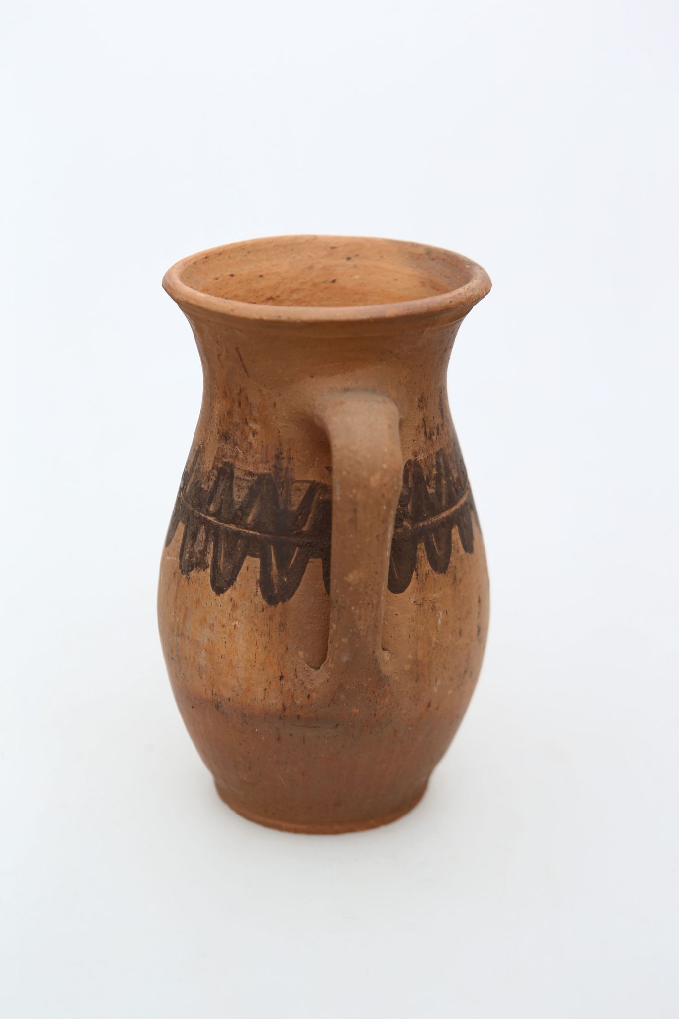 Vas ceramic nesmălțuit de formă sferoidală, cu gâtul înalt, ușor evazat și buza răsfrântă. Prevăzut cu o toartă lată care pleacăde la baza gâtului și se termină în zona inferioară. Toarta prezintă o curbură frântă din zona de la gatul vasului. Decorat în partea mediană cu motive zoomorfe (dintele de lup), dispuse în două rânduri, separate de o linie circulară. Decorul este pictat cu degetul, cu humă neagră. Pe toată suprafața, recipientul este ușor șlefuit cu piatra. Cromatică: fundal: cărămiziu; motive: negru.