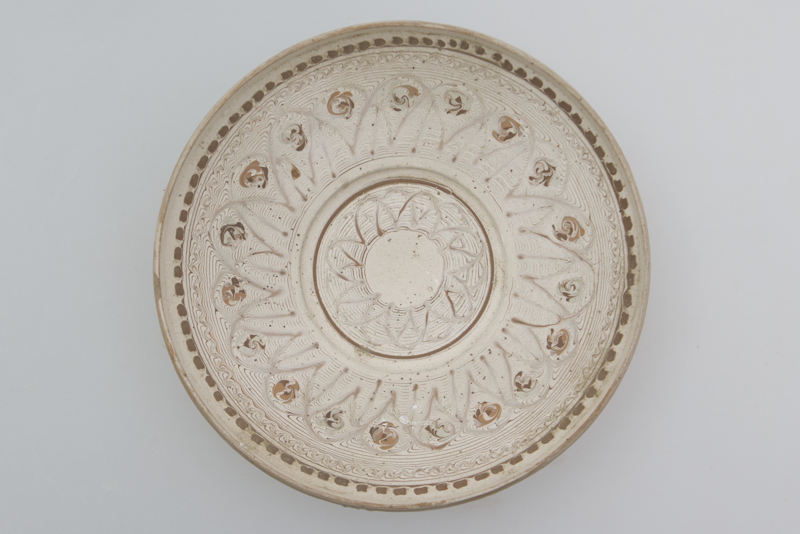 Vas de uz casnic, ceramic, de formă tronconică, ușor adâncit și buza rotunjită. Nesmălțuit și angobat. Prezintă decorații geometrice și florale pe întreaga suprafață interioară a vasului, realizate prin jirăvire cu gaița, în registre concentrice. În centrul vasului este redată o floare stilizată, separată de restul vasului cu o linie circulară, maro. Pe buza vasului, la interior, este pictat un șir de dreptunghiuri, maro. Cromatică: fond: alb; motive: negru; maro deschis; maro închis.