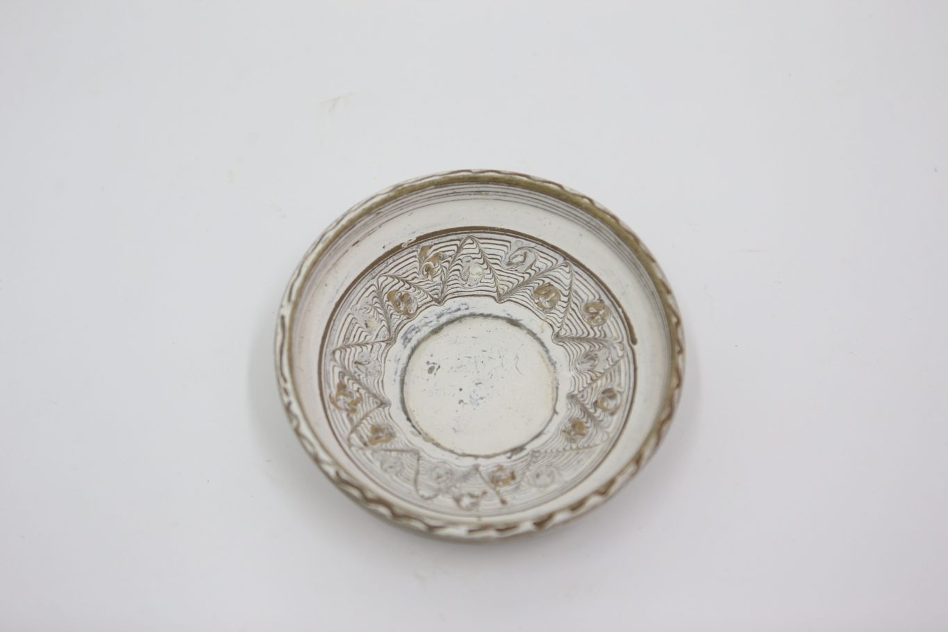 Vas de uz casnic, ceramic, nears, de formă circulară, cu profil tronconic, ușor adâncit și buza dreaptă. Nesmălțuit și angobat. Prezintă decorații geometrice și florale pe suprafața interioară a vasului, realizate prin jirăvire cu gaița și prin pictare cu cornul. Central, este redată o stea cu multe colțuri, încadrată de flori stilizate, tot ornamentul fiind încadrat într-un cerc maro. Sub buză, tot la interior, farfuria este decorată cu linii concentrice multiple, pictate cu cornul. Buza vasului prezintă o linie ondulată, maro. Cromatică: Fond alb, motive: negru, gri, maro deschis, maro închis.