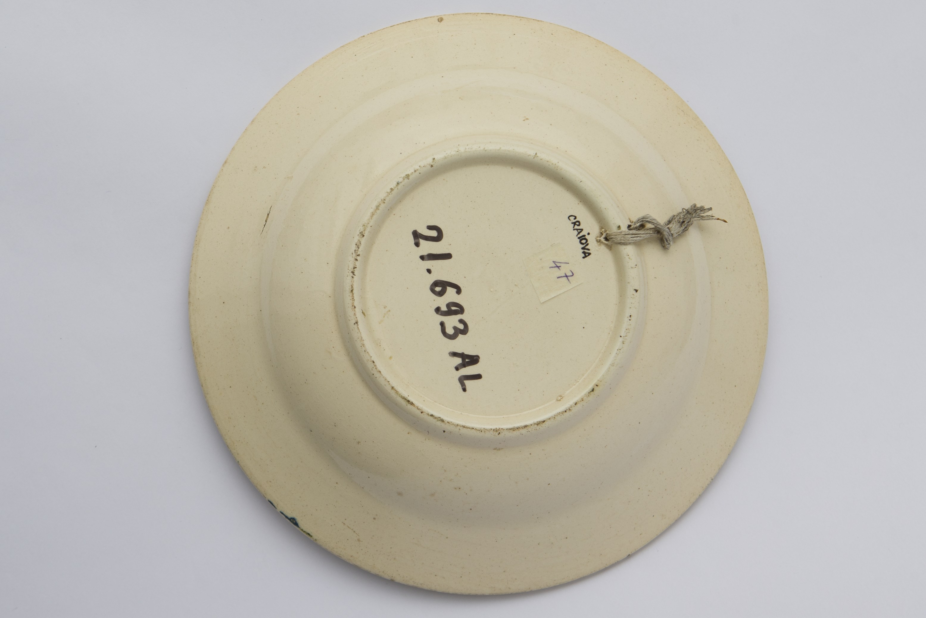 Vas ceramic de formă tronconică. Există două registre ornamentale, unul plasat de jur împrejurul buzei cu motive florale. Al doilea registru plasat în centru cu motive deasemenea florale ilustrând un buchet de flori într-un ghiveci. La posterior, baza inelară perforată pentru atârnare. Cromatică: fond: alb; motive: verde; albastru.