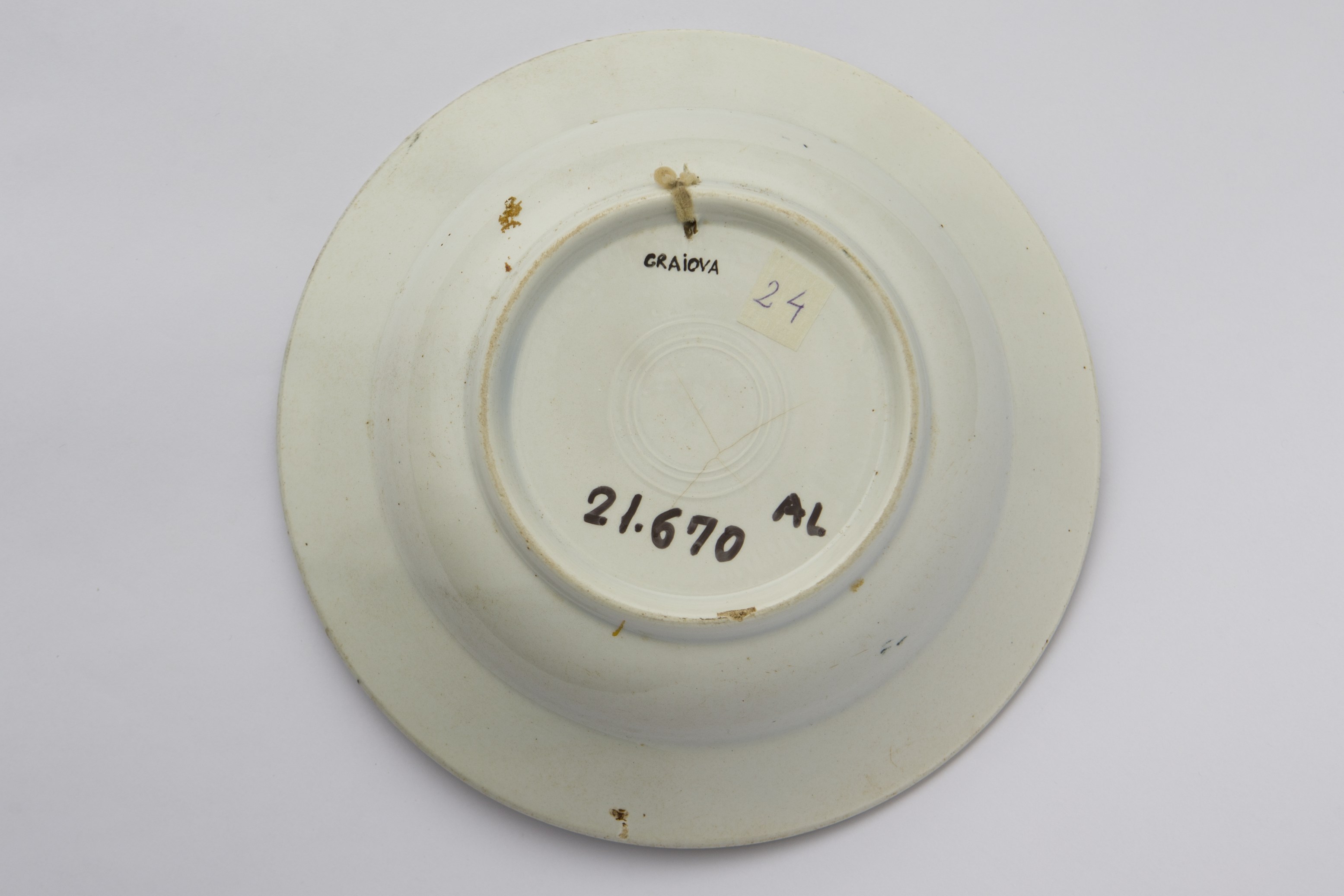 Vas ceramic de formă tronconică. Există două registre ornamentale, unul plasat de jur împrejurul buzei cu motive florale. Al doilea registru plasat în centru de asemenea motive florale. La posterior baza inelară perforată pentru atârnare. Cromatică: fond: alb; motive: verde; albastru.