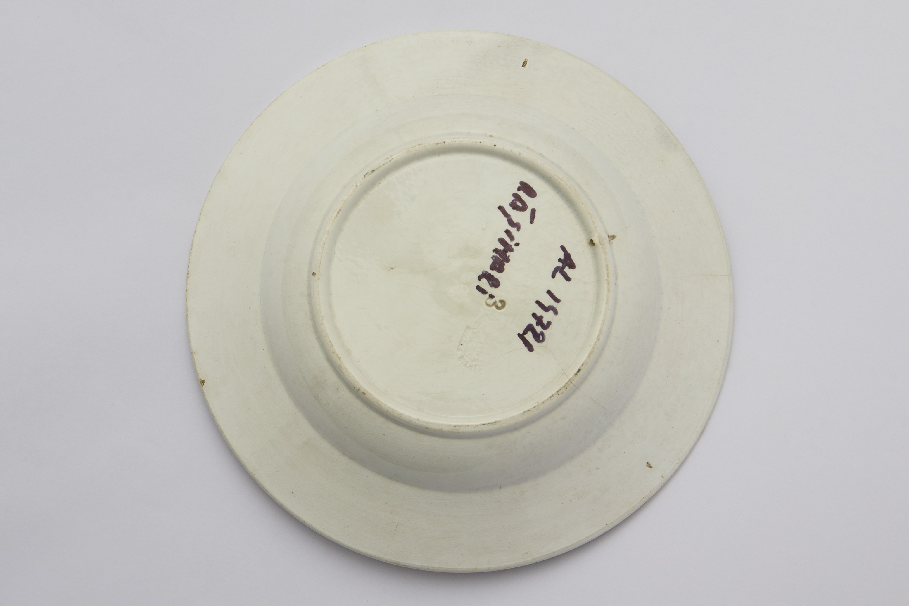 Vas ceramic de formă tronconică cu fundul plat, și marginile puțin ridicate. Pe fundul vasului amplasată o pasăre împreună cu motive floral - vegetale, ilustrate de o floare roșie cu doi boboci de floare și frunze verzi și albastre. Pe marginea vasului între două linii concentrice negre dispuse pe o bandă roșie ornamente floale stilizate. La posterior, baza inelară perforată pentru atârnare și o ștanță cu sigla și numele companiei producătoare ”Opaque Wilhelmberg''. Cromatică: fond: alb; motive: roșu; verde; negru; brun.