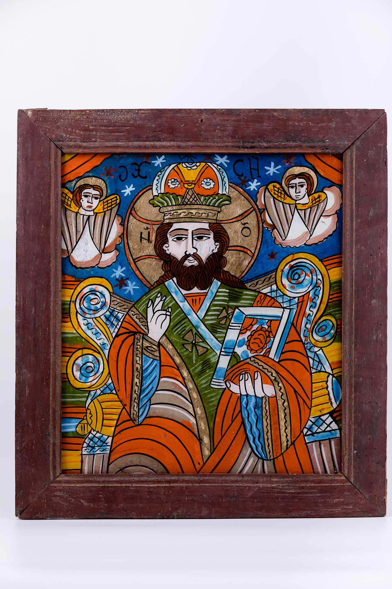Mântuitorul Iisus Hristos Pantocrator este tematica iconografică pictată, deobicei, pe bolta bisericii. Pantocrator înseamnă Atotțiitor, AtotStăpânitor. De aceea este și pictat pe locul cel mai înalt al unei biserici, binecuvântând de sus toată lumea care intră în sălașul sfânt de rugăciune. Iisus Hristos este înveșmântat într-o tunică-sacos roșu-vermillon-trandafiriu cu brun în interior, cu interiorul albastru, cu epitrahil-patrafir verde-albastru, mithră și aureolă, în veșminte liturgice arhierești. În mâna stângă ține Sfânta Evanghelie închisă. Cu mâna dreaptă binecuvântează. Fondul superior este cerul albastru cobalt, bogat ornamentat cu elemente astrale - stele roșii și albe. În registrul inferior, fondul este o alternanță de câmpuri paralele galbene, orange, albastre, cu dungulițe albe și negre. Tronul arhieresc este bogat ornamentat cu elemente de arhitectură galbene și albastre. În registrul superior cerul albastru este încadrat de drapajele roșii ale unei cortine, dezvăluitoare de Ușile Împărătești ale Altarului Cerului. În stânga și în dreapta sunt doi îngeri serafimi pe mandorle de nouri alb-crem. Cromatica este armonioasă, vie: roșu vermillon-trandafiriu, verde văratic, galben chihlimbar solar, albastru cobalt și ceruleum, brun, bej, alb, negru. Inscripția din româno-chirilică se traduce IC XC Iisus Hristos. Icoana este din Țara Oltului.