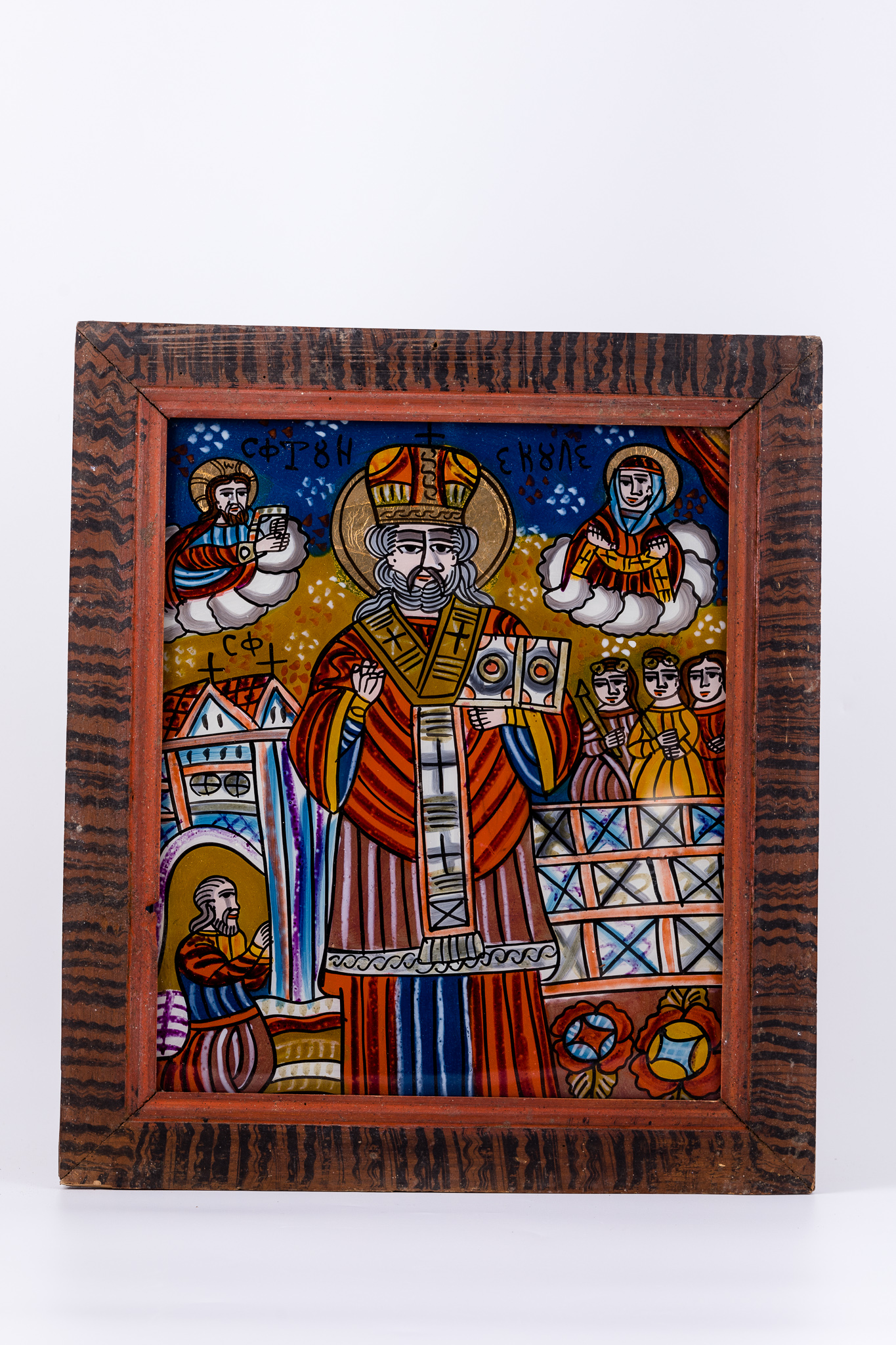 Sfântul Mare Ierarh Nicolae, făcător de minuni, îmbrăcat în veșminte liturgice, de ierarh, sacos roz-stacojiu, felon roșu vermillon-stacojiu, cu interiorul albastru și epitrahil-patrafir gri-bronziu, cu patru cruci negre brodate. Ține în mâna stângă Sfânta Evanghelie și cu mâna dreaptă Binecuvântează. Este unul dintre cei mai populari și iubiți sfinți, ocrotitor al caselor, familiilor și copiilor. Are barbă sură și mithră arhierească și aureolă. În registrul superior, sunt Dumnezeu-Tatăl Binecuvântând și Maica Domnului Ocrotind. Fondul este cerul albastru cobalt-ceruleum, împodobit cu elemente astrale - punctiflorale roșii și albe și un câmp luminos galben-auriu, în registrul mediu. În registrul mediu și inferior, sunt cele trei fete salvate și ajutate de Sfântul Nicolae și tatăl lor îngenuncheat, mulțumind pentru minunea săvârșită. Desenul este fin conturat. Cromatica este armonioasă: roșu vermillon, stacojiu-roz putred, albastru ceruleum și cobalt, galben muștar ocru, bronz, brun, bej, crem, auriu, alb, negru. Inscripția în chirilică se traduce Sfântul Nicolae. Icoana este de Țara Oltului.