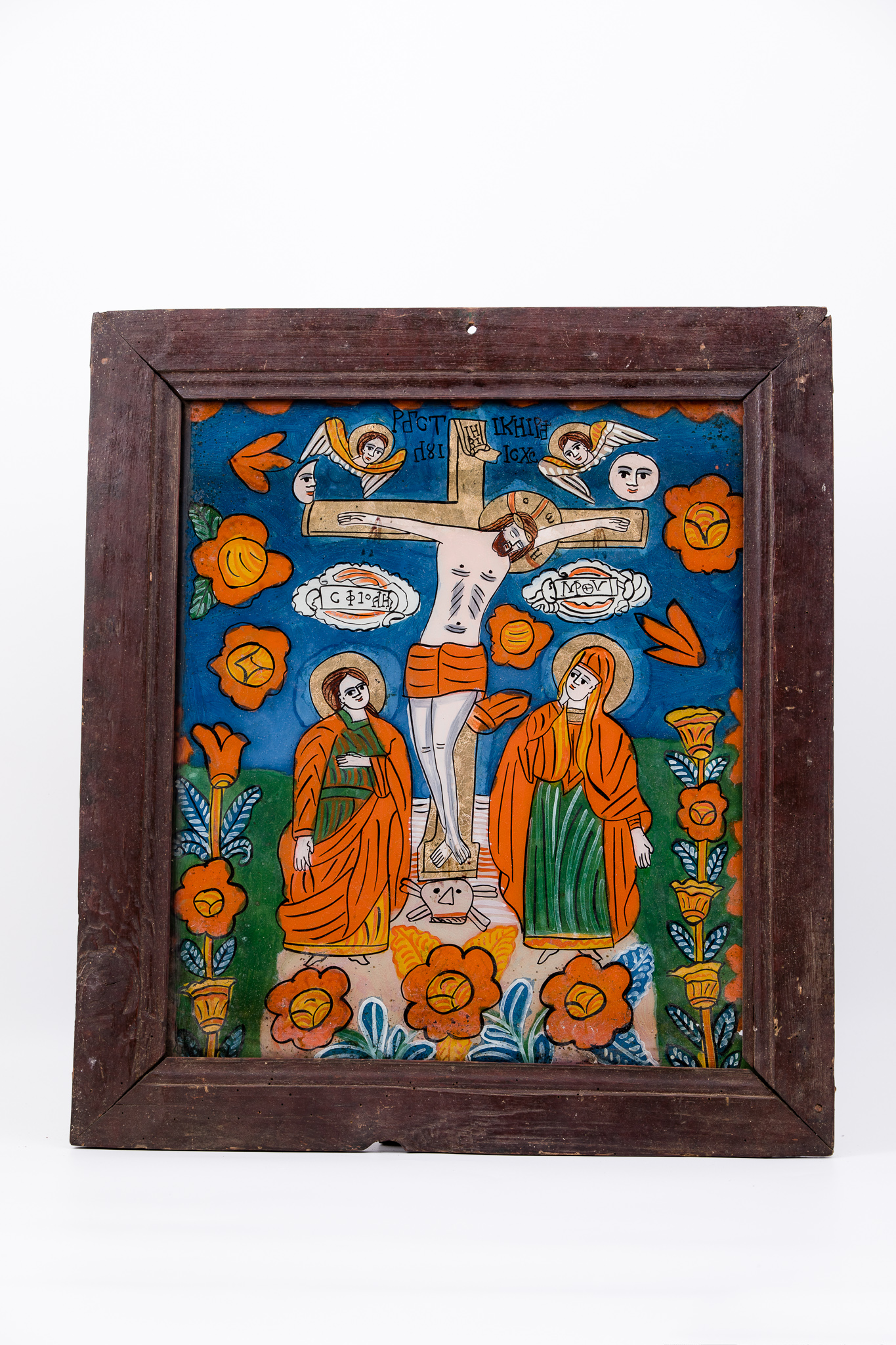 Mântuitorul Iisus Hristos, fiind răstignit pe Cruce, are în dreapta pe ucenicul cel iubit, care a stat lipit de pieptul Învățătorului, la Cina cea de Taină, mai precis, pe Sfântul Apostol și Evanghelist Ioan Teologul, Evanghelistul Iubirii și în stânga pe Maica Domnului Îndurerată, Jalnică și Plângătoare. Veșmintele Maicii Domnului sunt roșii vermillon-orange și verzi și mantia roșie vermillon. Sfântul Ioan este îmbrăcat în verde-orange și roșu vermillon. Mântuitorul Iisus Hristos are o țesătură roșie în jurul mijlocului și a coapselor. În planul superior sunt simboluri astrale: soarele, deasupra Maicii Domnului, luna, deasupra Sfântului Ioan. Lângă elementele astrale sunt doi îngeri serafimi, cu aripile alb-ocru luminoase. Fondul icoanei este cerul albastru ultramarin bleumarin întunecat, de noapte, în registrul superior și verde-văratic, în registrul inferior. Întreaga compoziție iconografică este presărată de elemente florale - ruje roșii, cu miezul - caliciul și pistilul galben chihlimbar. Cromatica este armonioasă: roșu vermillon, orange, galben chihlimbar, albastru ultramarin bleumarin, verde-văratic, alb, negru.Inscripția din româno-chirilică se traduce Răstignirea Lui IC XC Iisus Hristos MP Maica Domnului Sf Ioan. Icoana este din Țara Oltului.