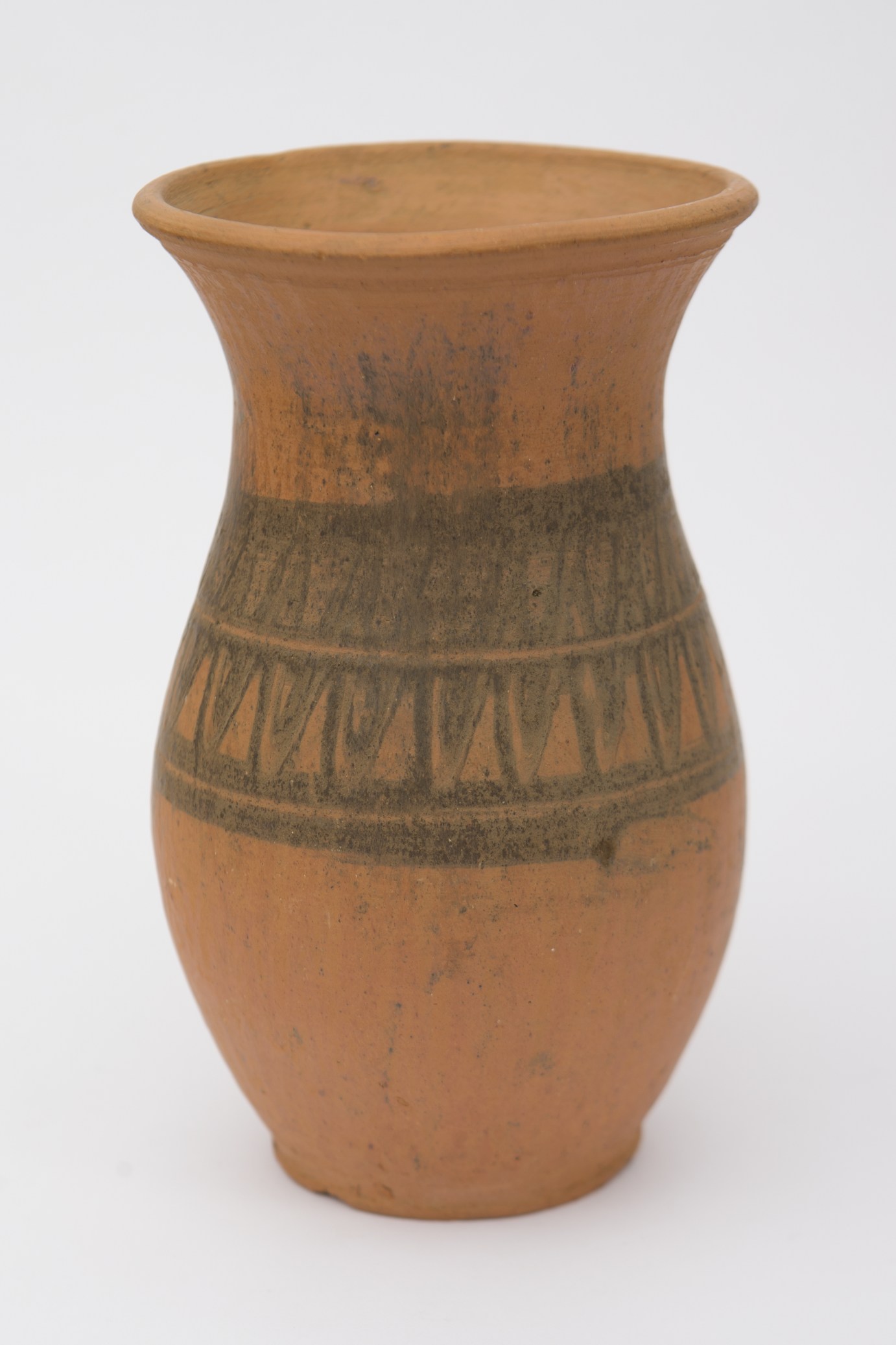 Vas ceramic nesmălțuit de formă sferoidală, cu gâtul înalt, ușor evazat și buza răsfrântă. Prevăzut cu o toartă care pleacă din gât și se termină în zona inferioară. Decorat în partea mediană cu motive zoomorfe (dintele de lup), dispuse în două rânduri, separate la mijloc și încadrate la margini de linii circulare. Decorul este pictat cu cornul, cu humă neagră. Pe toată suprafața, recipientul este ușor șlefuit cu piatra. Cromatică: fundal: cărămiziu; motive: negru.