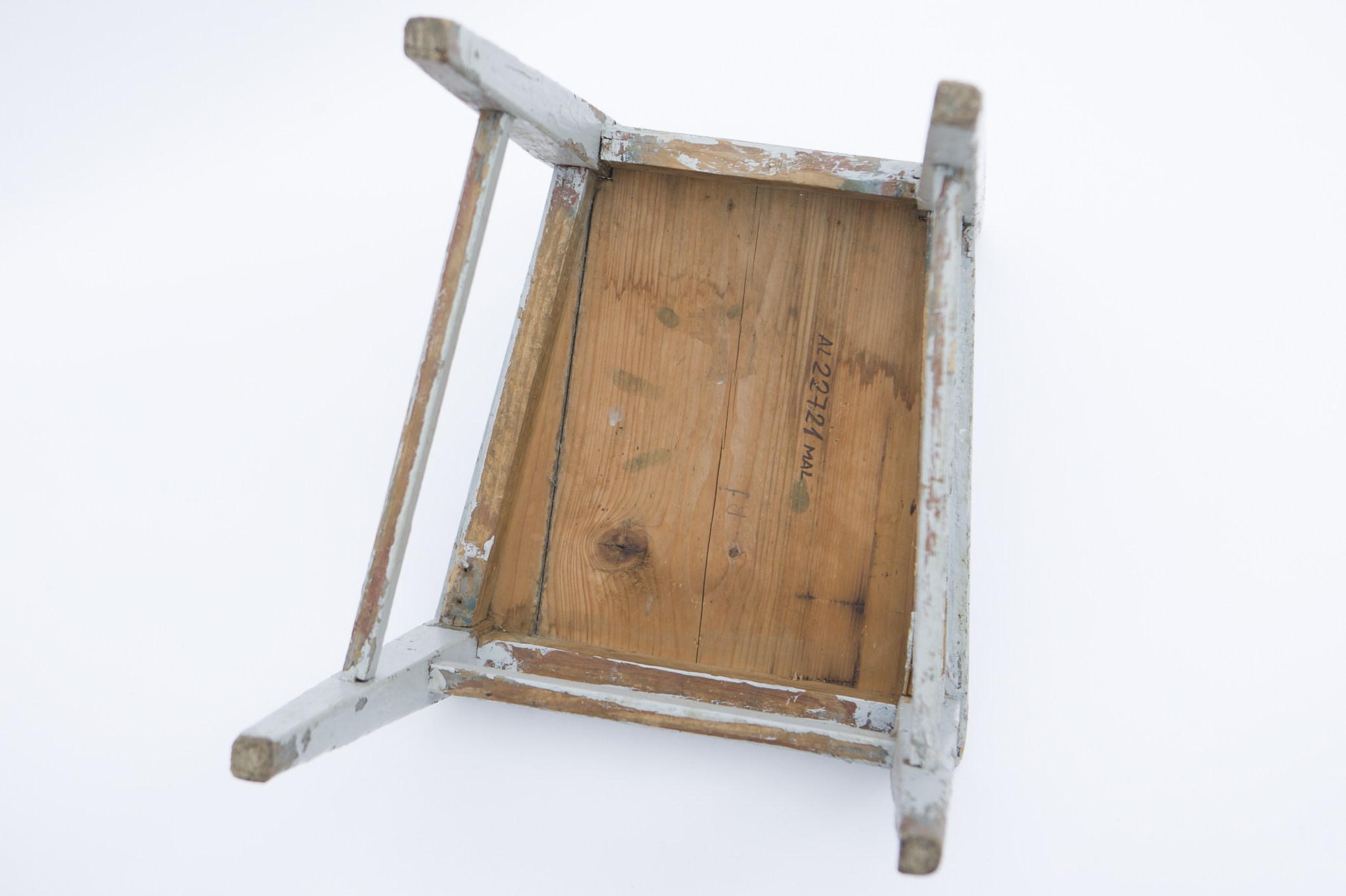 Obiect de mobilier de formă trapezoidală, realizat din lemn de brad și metal. Scaunul este format din blatul de formă trapezoidală și cele patru picioare, pe care se sprijină. Picioarele din spate se prelungesc, formând astfel spătarul. La nivelul acestuia, două scânduri orizontale încadrează trei scânduri verticale. Sub blat, patru scânduri dispuse orizontal pe grosime, consolidează piesa. Alte patru scânduri, dispuse similar, în zona mediană a picioarelor, întăresc piesa. Nu prezintă decor. Scaunul era folosit în gospodărie pentru mobilarea interioarelor. Prezintă uzură funcțională. Cromatică: gri-albăstrui.