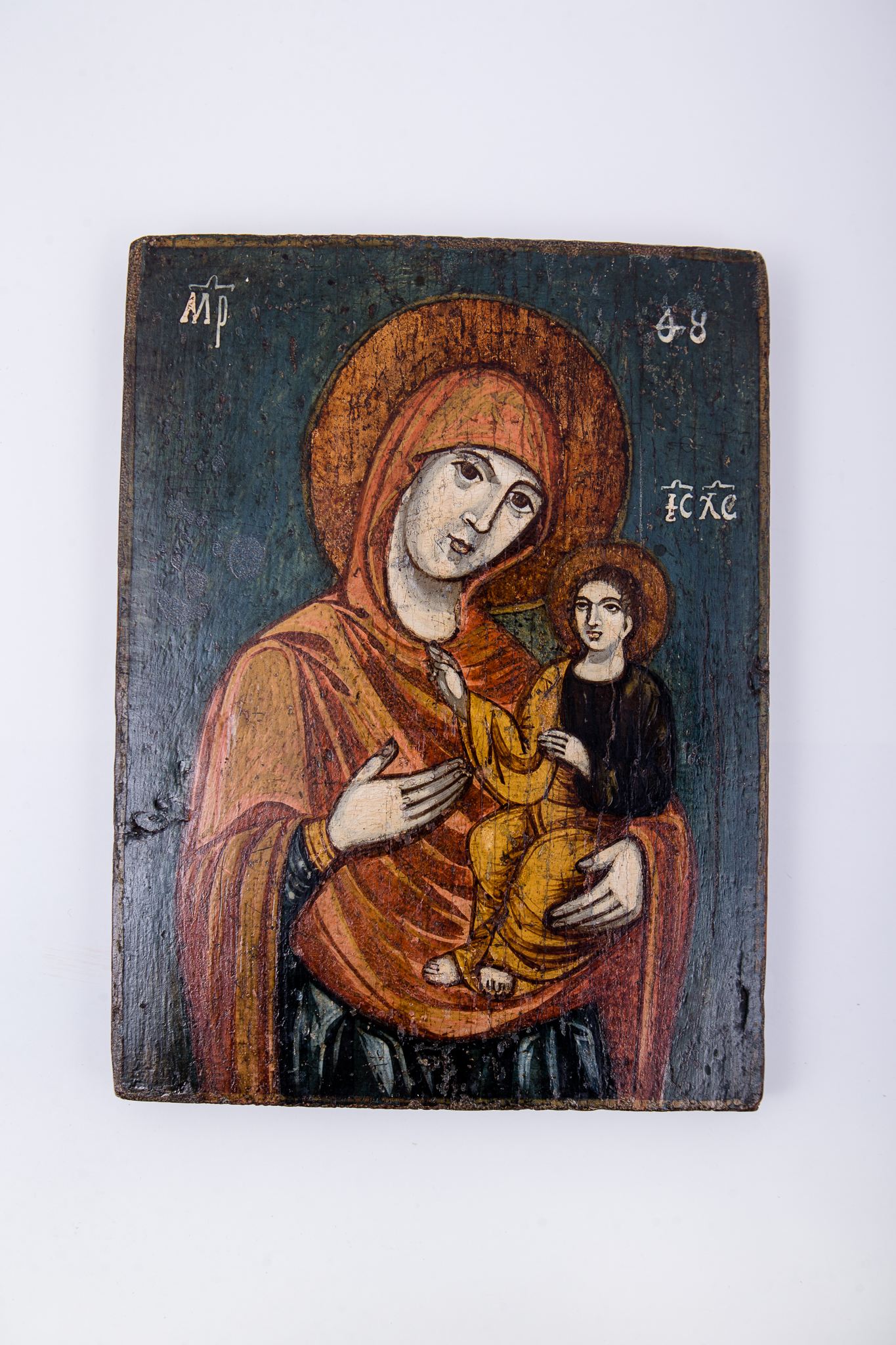 Maica Domnului ține în brațe Pruncul Iisus Hristos, care arată cu mâna dreaptă înspre Maica Domnului, prezentându-ne-o. Maica Domnului este înveșmântată în mantie cu maforion ocru-galben cu interiorul negru și ciupag auriu. Pruncul Iisus Hristos este înveșmântat cu omofor ocru-galben și sacos negru interior, cu aureolă. Maica Domnului cu mâna dreaptă ni-L arată pe Mântuitorul Iisus Hristos ca fiind Calea, Adevărul și Viața, este tip Hodighitria. Culorile Maicii Domnului reprezintă noblețea împărătească, suferința monahică și nădejdea bucuriei Învierii. Culorile Mântuitorului reprezintă suferința monahică și patima dureroasă a Jertfei. Fondul icoanei este negru-întunecat, realizându-se un contrast puternic cu chipurile și veșmintele sfinte.Chipurile și trăsăturile fețelor sunt luminoase prin privire, atitudine și aureole. Cromatică: galben-ocru, brun, bej, negru. Inscripția din româno-chirilică se traduce MP IC XC Maica Domnului Iisus Hristos.