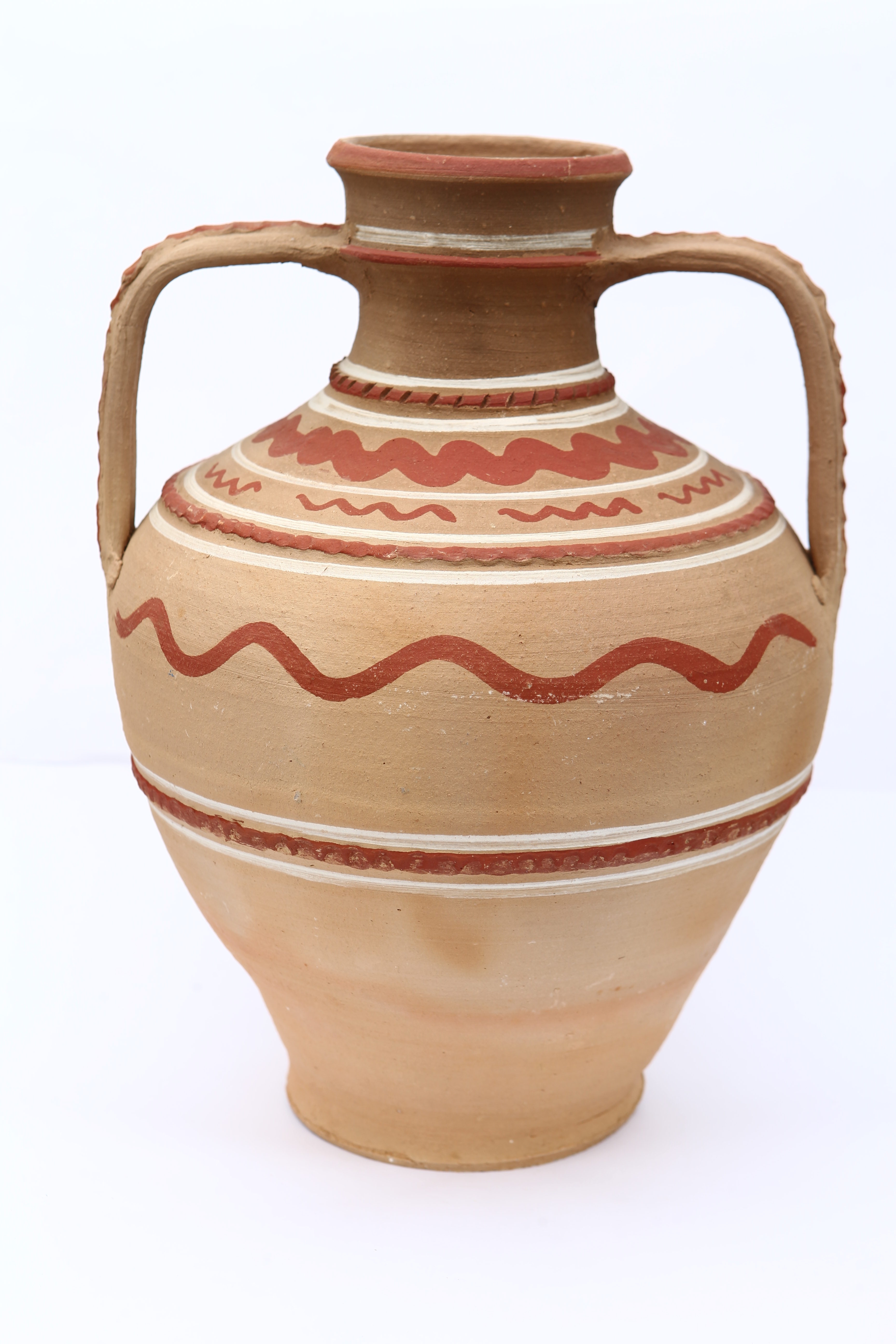 Recipient ceramic nesmălțuit, de formă bitronconică, cu gâtul lung și buza dreaptă. Prevăzut cu două toarte late dipuse de-o parte și de alta a vasului, în unghi drept, care pleacă din manșonul gâtului și se termină în zona umerilor. Decorat atât pe toarte cât și pe corpul vasului cu brăuri alveolare. În partea superioară, ulciorul prezintă și motive geometrice (linii concentrice, linii șerpuite) , pictate cu pensula. Cromatică: fundal maro motive: roșu închis, alb.