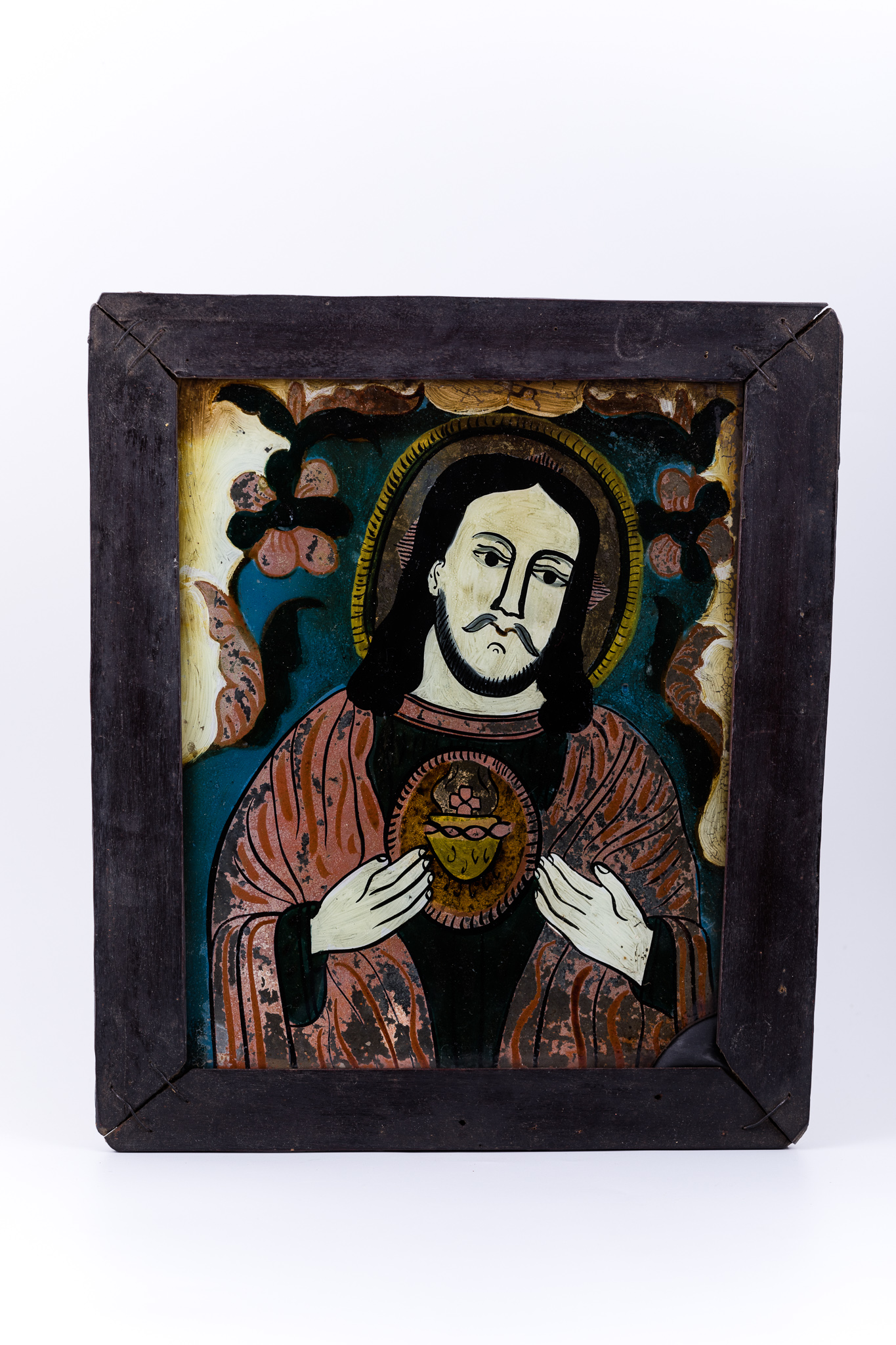 Mântuitorul Iisus Hristos este înveșmântat într-o tunică-sacos gri-antracit înspre negru și mantie roșie vermillon, având deschisă inima cu raze luminoase-aurii. Cu amândouă mâinile Își dăruiește inima aurită cu har. Are părul negru lung, lăsat pe umeri și aureolă galbenă. Fondul icoanei este cerul albastru ceruleum-regal, înconjurat de un chenar decorativ ivoriu-crem și întreaga compoziție iconografică este încadrată de un chenar decorativ fitomorf, format dintr-o ghirlandă de ruje - 2 ruje mari cu șase petale roșii-negre, cu formă de margarete. Cromatica este armonioasă și discret de luminoasă: roșu vermillon-roz, verde kaki, albastru ceruleum și regal, cobalt, brun cafeniu, galben-ocru-muștar, alb, negru. Icoana este rară din punctul de vedere al tematicii abordate - Iisus Hristos cu Inima, tematică cu influențe catolice și pictural-apusene. Icoana este din Nordul Transilvaniei, Nicula.