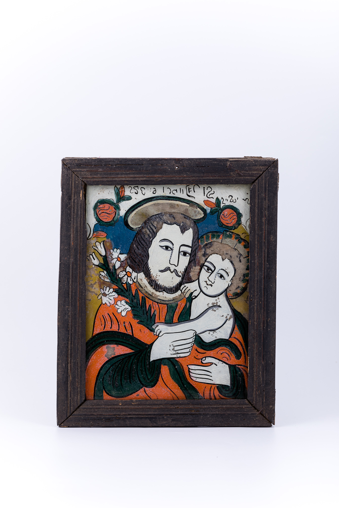 Icoana îi reprezintă pe Sfântul și Dreptul Iosif, Logodnicul PreaCuratei Fecioarei Maria, cu Pruncul Iisus Hristos în brațe. Icoana este mai rară, din punctul de vedere al tematicii compoziționale abordate. Sfântul Iosif este înveșmântat cu un hiton - tunică roșie vermillon, cu mânecile și bordura verde mușchi-de-pădure sau nuanță de China. Pruncul Iisus este dezbrăcat, dar acoperit de veșmântului protector al Sfântului Iosif. În mâna dreaptă Dreptul Iosif Logodnicul ține o ramură de crin, simbolul Fecioriei și a BuneiVestiri. Crinul este ținut împreună cu mânuța Pruncului Sfânt. Aureola Sfântului Iosif este mai aparte, asemenea sfinților catolici. Fondul icoanei este cerul albastru regal, în registrul superior, un câmp luminos de galben-bronziu, în registrele inferior și mediu, pe laterale și un chenar decorativ geometrizant alb-ivoriu. În registrul superior, asemenea unei arcade de boltă, este o ghirlandă de ruje roz - 2 elemente florale. Inscripția din româno-chirilică se traduce Sf Iosif și Iisus. Cromatica este armonioasă și luminos-pastelată: roșu vermillon, verde mușchi-de-pădure, albastru regal, alb-ivoriu, crem, bej, nisipiu, galben-ocru, bronziu, alb, negru. Icoana este din Nordul Transilvaniei, Nicula.