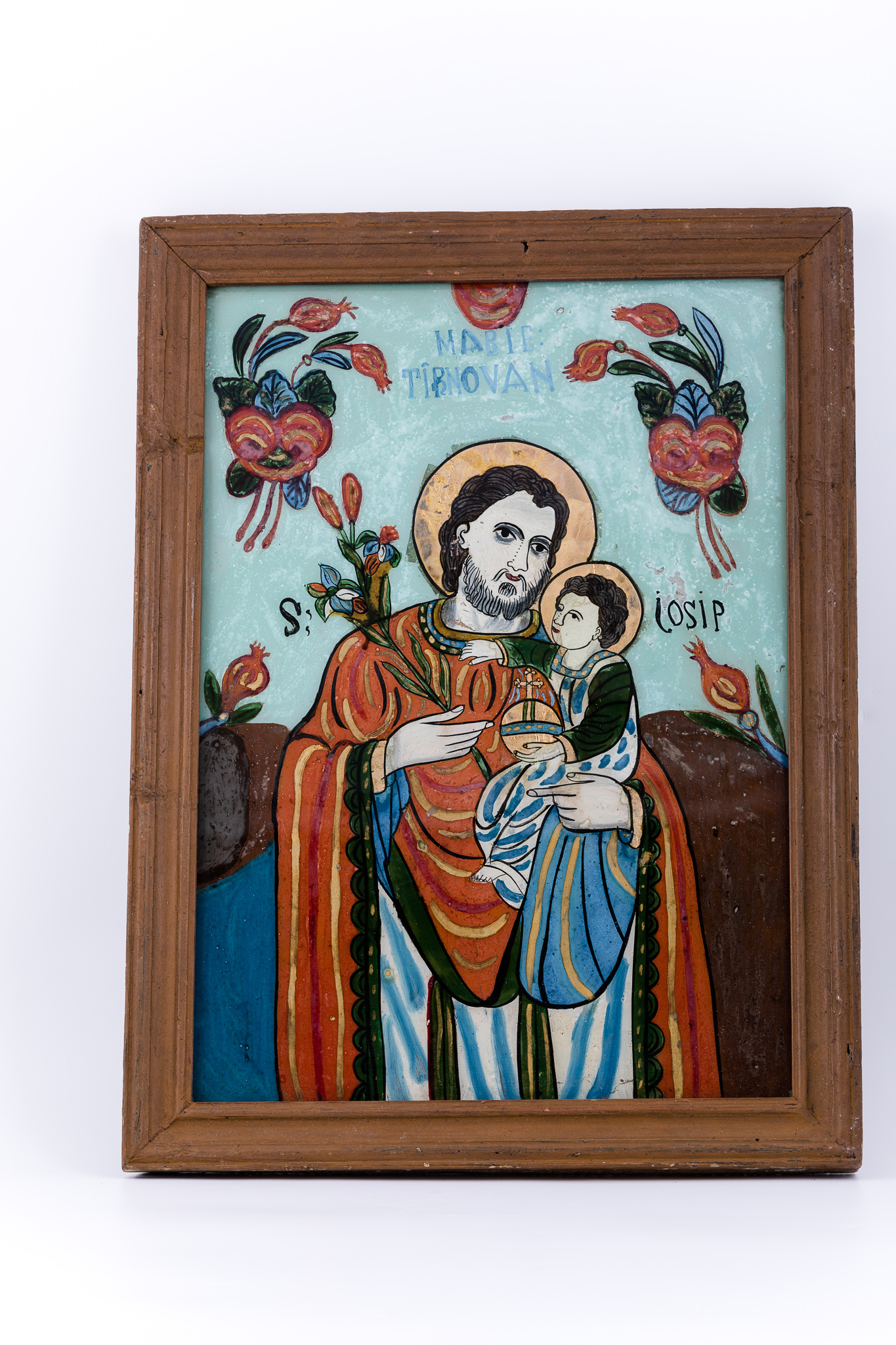 Icoana îi reprezintă pe Sfântul și Dreptul Iosif, Logodnicul PreaCuratei Fecioarei Maria, cu Pruncul Iisus Hristos în brațe. Icoana este mai rară, din punctul de vedere al tematicii compoziționale abordate. Sfântul Iosif este înveșmântat cu un hiton - tunică roșu vermillon, cu mânecile și bordura verde mușchi-de-pădure sau nuanță de China. Sacosul alb are dungi albastre și mânecile mantiei roșii, cu interiorul albastru, are dungi ocru-bronzii. Pruncul Iisus este îmbrăcat cu un sacos albastru-alb, cu mânecile verzi-kaki. În mâna dreaptă Dreptul Iosif Logodnicul ține o ramură de crin, simbolul Fecioriei și a BuneiVestiri. Pruncul Iisus ține cu mânuța stângă globul pămânesc pe genunchi, iar cu mâna dreaptă ține pe Sfântul Iosif pe după gât. Aureola Sfântului Iosif este mai aparte, asemenea sfinților catolici. Fondul icoanei este cerul albastru bleu-ciel ceruleum, în registrul superior, un câmp brun-acajou în registrele inferior și mediu, pe laterale. În registrul superior, asemenea unei arcade de boltă, este o ghirlandă de ruje roz - 2 grupuri de elemente florale. Inscripția din româno-chirilică se traduce Sf Iosif. Cromatica este armonioasă și luminos-pastelată: roșu vermillon, verde mușchi-de-pădure, kaki, albastru bleu-ciel, regal, alb-ivoriu, crem, bej, nisipiu, galben-ocru, bronziu, alb, negru. Icoana este de pe Valea Sebșului, Laz.