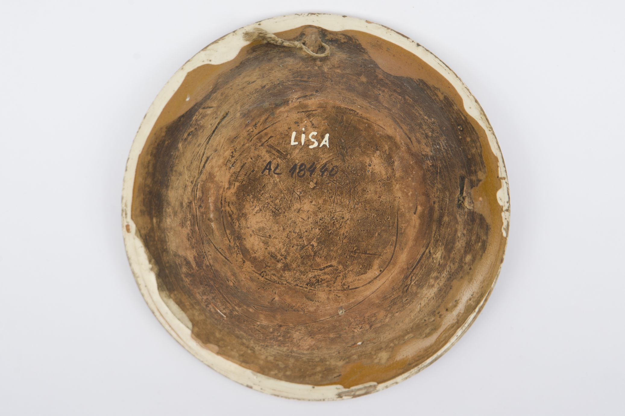Recipient ceramic smălțuit la interior, de formă tronconică, cu baza plată, pereții înalți și marginea profilată. Peste stratul crem de angobă a fost pictat decorul geometrizant și fitomorf stilizat: Pe fundul vasului au fost realizate patru flori maro, cu mijlocul verde și albastru, fiind mărginite de patru grupuri de câte nouă puncte verzi și albastre (două câte două, în diagonală). Cel de-al doilea registru pictural a fost realizat marginal, pe buza piesei fiind încadrat între două linii circulare drepte un șir de „V-uri” succesive. Farfuria era folosită în gospodărie pentru decorarea interioarelor sau servirea hranei. Prezintă uzură funcțională: Cromatică: fond: cărămiziu; crem; motive: maro; verde; albastru.